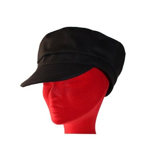 Peut inclure: Une casquette de newsboy en coton noir avec une visi&egrave;re plate et une couronne l&eacute;g&egrave;rement arrondie.