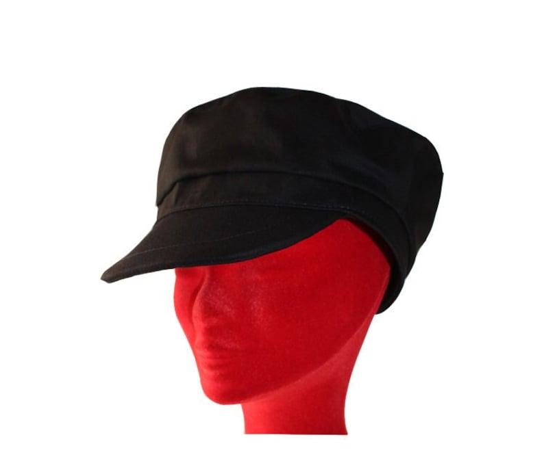 Peut inclure: Une casquette de newsboy en coton noir avec une visi&egrave;re plate et une couronne l&eacute;g&egrave;rement arrondie.