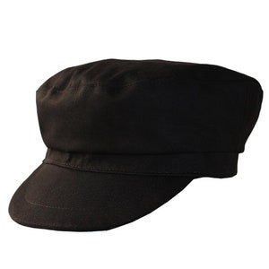 Peut inclure: Une casquette de newsboy en coton noir avec une visi&egrave;re courte.