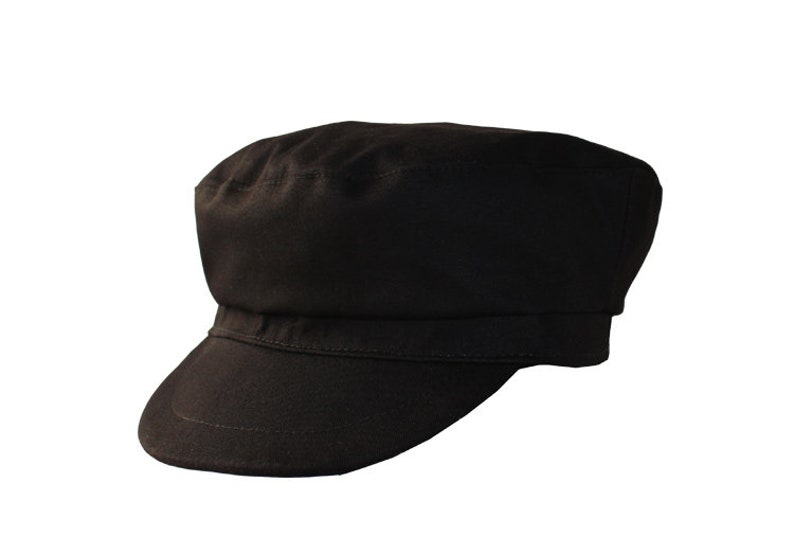 Peut inclure: Une casquette de newsboy en coton noir avec une visi&egrave;re courte.