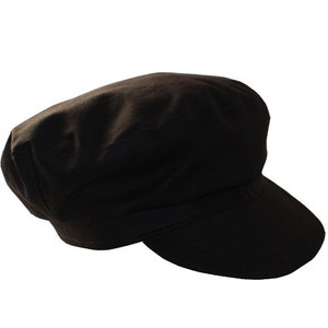 Peut inclure: Une casquette de newsboy en coton noir avec une visi&egrave;re plate.