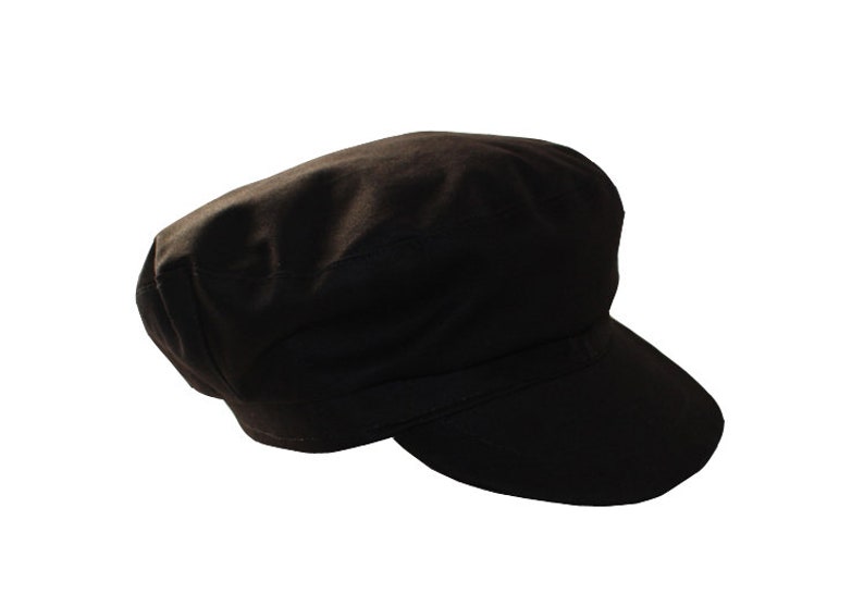 Peut inclure: Une casquette de newsboy en coton noir avec une visi&egrave;re plate.