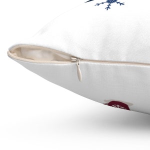 May include: White pillow with a zipper closure. The pillow has a red and white snowflake design on one side and a blue snowflake design on the other side.