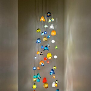 a collection of colorful glass or ceramic objects suspended from the ceiling, creating a visually striking display.