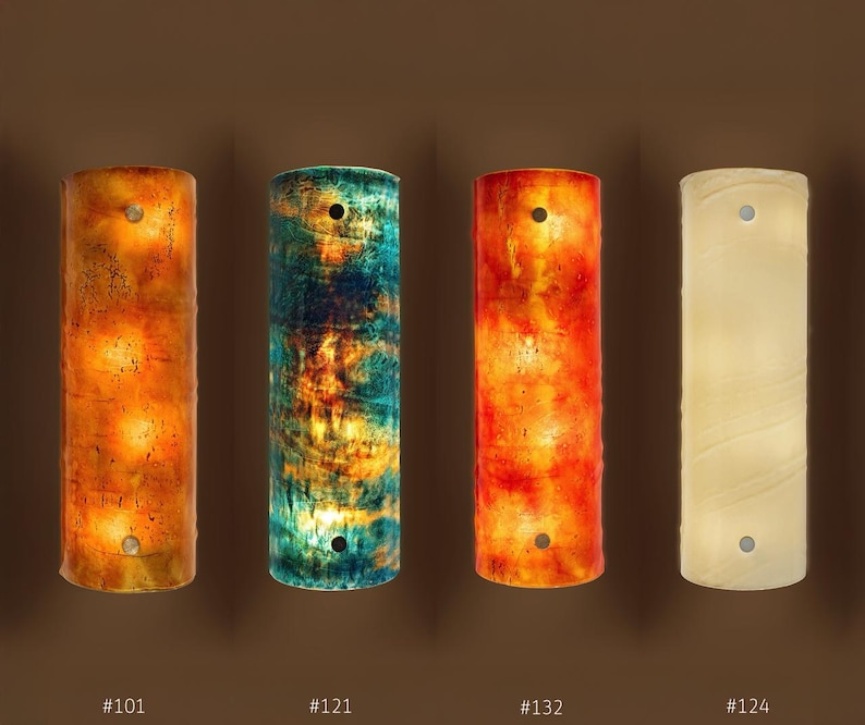 a group of four different colored vases sitting next to each other