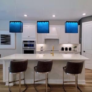 Arte funcional para la isla de tu cocina: una lámpara de araña moderna y un colgante de cristal a medida que sirven como iluminación arquitectónica para la isla. 119 Blue Depth