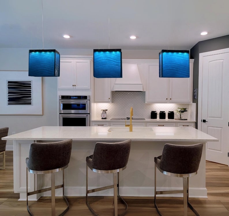 Arte funcional para la isla de tu cocina: una lámpara de araña moderna y un colgante de cristal a medida que sirven como iluminación arquitectónica para la isla. 119 Blue Depth