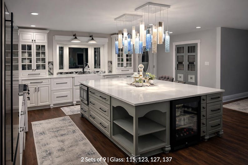 A modern and spacious kitchen with white cabinets, a large central island, and a hanging light fixture.