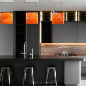 Arte funcional para la isla de tu cocina: una lámpara de araña moderna y un colgante de cristal a medida que sirven como iluminación arquitectónica para la isla. 107 Golden Sand