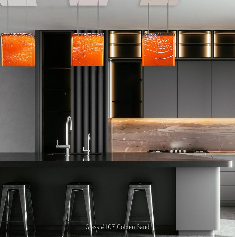 Arte funcional para la isla de tu cocina: una lámpara de araña moderna y un colgante de cristal a medida que sirven como iluminación arquitectónica para la isla. 107 Golden Sand