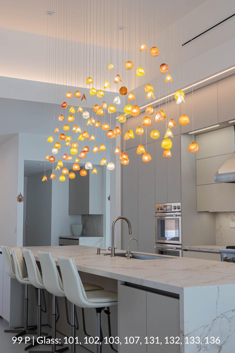 a modern kitchen with a large, hanging light fixture composed of numerous glass spheres in various colors, creating a visually striking and vibrant atmosphere.