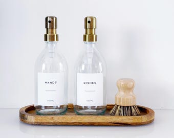 Set Of 2 Clear Bottles - Glass Or Plastic - Hands & Dishes - Brushed Gold Metal Pumps