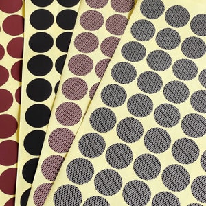 May include: A close-up of a sheet of adhesive-backed circles in various colours and patterns. The circles are arranged in rows and columns, and they are all the same size. The circles are ideal for crafting, scrapbooking, and other DIY projects.