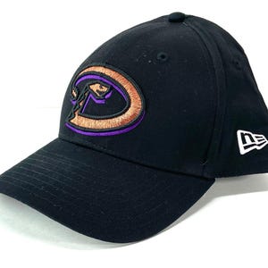 May include: Black baseball cap featuring the Arizona Diamondbacks logo in purple, orange, and brown. The cap has a curved brim and the New Era logo on the side. A classic baseball cap style.
