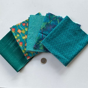 Puede incluir: Cinco cuadrados de tela en varios tonos de verde azulado y verde con diferentes patrones. Los patrones incluyen un patrón de pequeños puntos blancos, un patrón geométrico de diamantes, un patrón floral con acentos naranja y rojo, y un patrón con pequeños puntos azules, verdes y rosas.