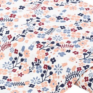 May include: White fabric with a repeating pattern of small pink, red, and blue flowers and leaves.