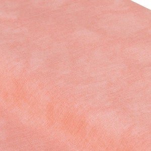 May include: A close-up of a smooth, peach-colored fabric with a subtle texture. The fabric is soft and has a slightly iridescent sheen.