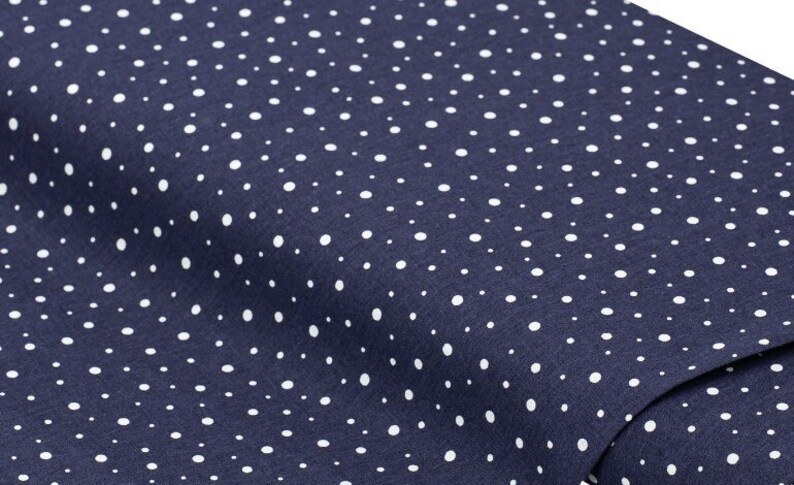 May include: A navy blue fabric with a white polka dot pattern.
