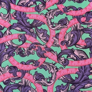 Peut inclure: Tissu avec un motif répété de mètres rubans roses et d'éléments floraux baroques violets sur un fond vert clair. Les mètres rubans ont des graduations en pouces. Ce tissu est adapté aux projets de couture et d'artisanat.
