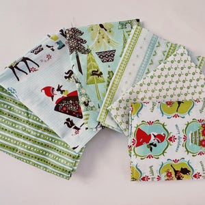 Peut inclure: Une collection de carrés de tissu pliés présentant divers motifs sur le thème des fêtes. Les designs incluent des rayures vertes, des sapins de Noël stylisés, des formes géométriques et des illustrations avec le texte merry christmas.