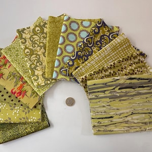 May include: A collection of square fabric swatches arranged in a fan shape, featuring various patterns in shades of olive green, lime, brown, and light blue. A small silver coin is placed in the center for scale, measuring approximately 0.95 inches.