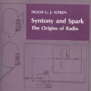 Peut inclure: Un livre intitulé "Syntony and Spark: The Origins of Radio" de Hugh G. J. Aitken. La couverture présente un fond violet avec plusieurs illustrations en noir et blanc de matériel radiophonique ancien.