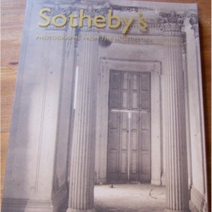 May include: A book cover with the title "Sotheby's Photographs from the Museum of Modern Art" in gold lettering. The cover features a black and white photograph of a doorway with two columns on either side.