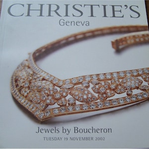 May include: A close-up of a gold and diamond necklace with a floral design. The necklace is displayed on a white background with the text "Jewels by Boucheron" and "TUESDAY 19 NOVEMBER 2002".
