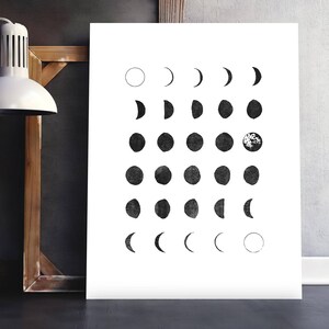 May include: A black and white illustration of the phases of the moon. The moon is depicted in various stages of its cycle, from a full moon to a crescent moon. The illustration is a simple and elegant design that would look great in any home.
