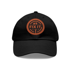 May include: Black baseball cap with an orange embroidered patch that says "MR. FIX IT" with a wrench icon.
