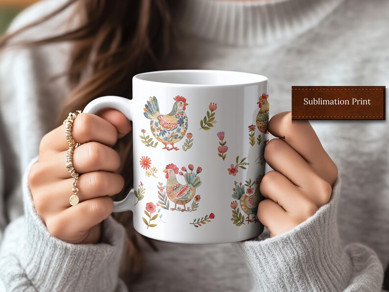 May include: White ceramic mug with a sublimation print of colorful chickens and floral designs. The mug is being held by a person's hands.