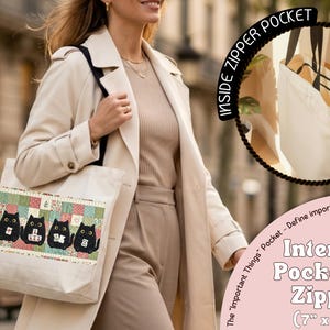 May include: A cream-colored canvas tote bag featuring a horizontal patchwork-style panel with four black cat illustrations. The bag includes an interior pocket with a zipper measuring 7 inches by 7 inches, labeled as the Important Things Pocket.