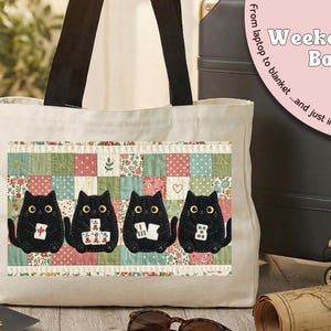 May include: A cream-colored canvas tote bag with black shoulder straps. The front features a rectangular patch with a patchwork quilt pattern in muted colors, displaying four black cats holding mahjong tiles with yellow eyes.
