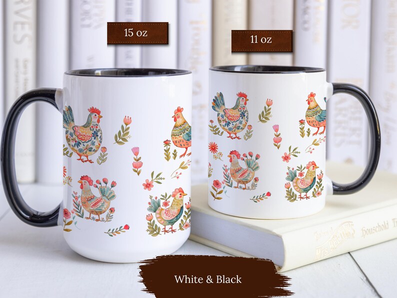 May include: Two white ceramic mugs with black rims and handles. Both mugs feature a colorful pattern of stylized chickens and flowers. The mug on the left is 15 oz and the mug on the right is 11 oz.