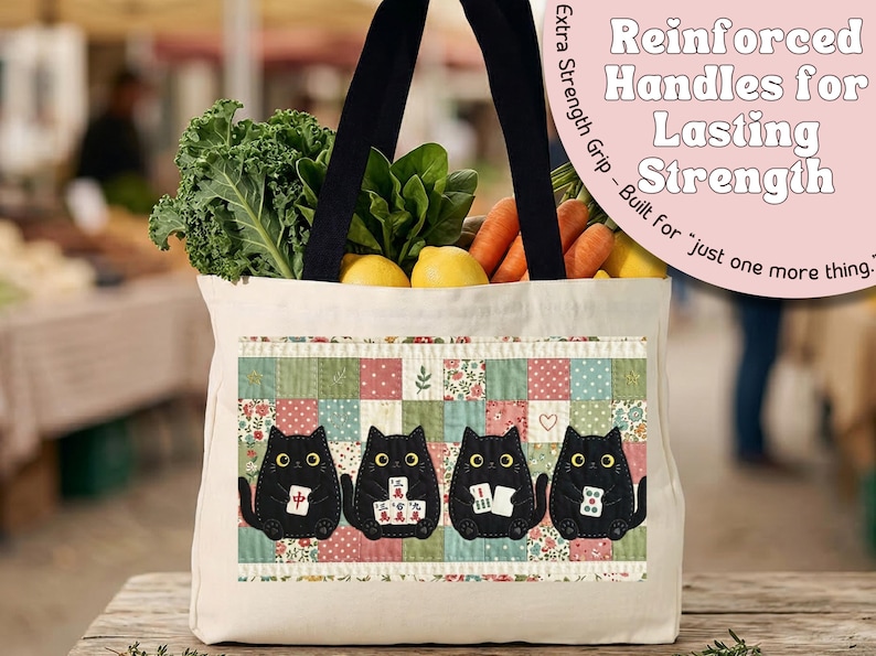 May include: A cream-colored canvas tote bag with black handles, filled with fresh kale, carrots, and lemons. The front features a patchwork design with four black cats holding mahjong tiles. Text reads: Reinforced Handles for Lasting Strength.