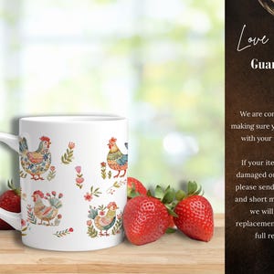 May include: White ceramic mug with a colorful rooster design. The mug has a handle and is surrounded by strawberries.