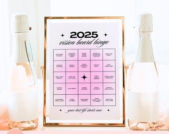 May include: A framed 2025 vision board bingo template with a gold frame, featuring a pink and white design. The bingo card includes goals like "Eat More Veggies" and "Learn a New Language." Two champagne bottles flank the board, creating a celebratory theme.