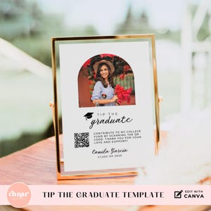 May include: A white sign with a gold frame, featuring a photo of a graduate in a cap and gown. The sign reads "Tip the Graduate" and includes a QR code. The text also says "Contribute to my college fund by scanning the QR code. Thank you for your love and support!" and "Camila Garcia, Class of 2025."