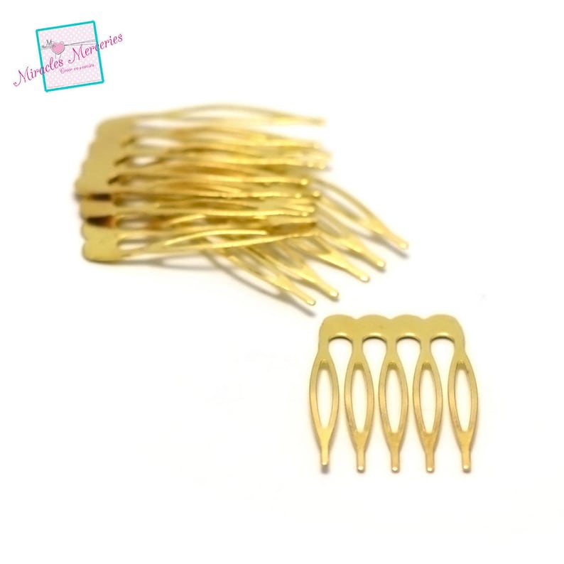 May include: A close-up of a pile of gold-colored hair clips. The clips are small and have a comb-like design.