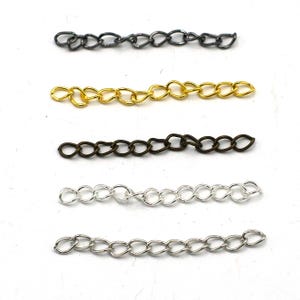 Peut inclure: Cinq styles de chaînes différents en noir, or, bronze, argent et blanc. Chaque chaîne mesure environ 5 cm de long.