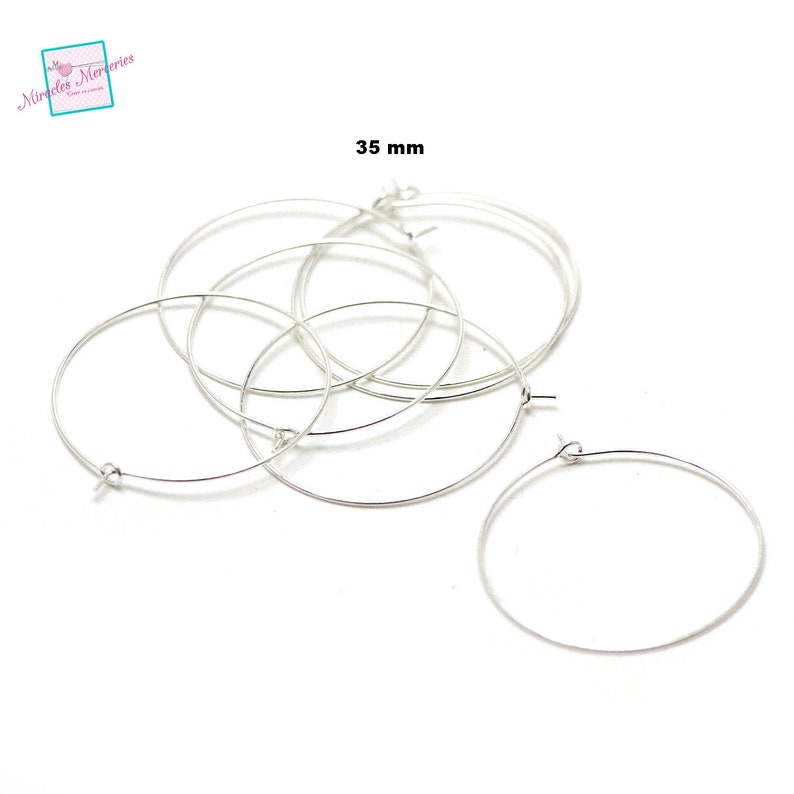 Pu&ograve; includere: Cinque orecchini a cerchio in argento, ognuno con un diametro di 35 mm. Gli anelli sono in filo sottile e hanno un design semplice ed elegante.