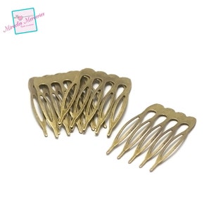 May include: A pile of 10 gold metal hair clips with a comb design. The clips are about 2 inches long and have a slightly curved shape.