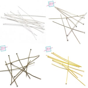 Op de afbeelding: Assortiment van kopspelden in zilver, goud en brons. De kopspelden zijn ongeveer 5 cm lang en ideaal voor het maken van sieraden.