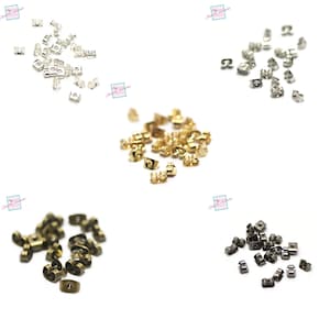 Peut inclure: Assortiment de dos d'oreille en différentes finitions, notamment argent, or, bronze et noir. Les dos sont en métal et ont une petite boucle pour fixer les boucles d'oreilles.