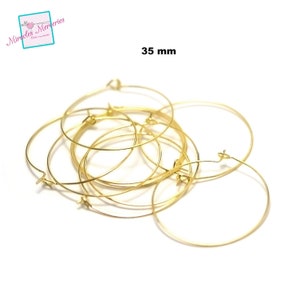 Pu&ograve; includere: Un mucchio di orecchini a cerchio dorati da 35 mm.