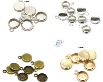 Puede incluir: Surtido de engastes redondos de metal de 8 mm con un bucle para colgar. Los engastes están disponibles en plata, bronce y oro.