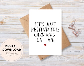 May include: A white card with black text that reads "Let's just pretend this card was on time". A red heart is below the text. The card is sitting on a brown envelope.