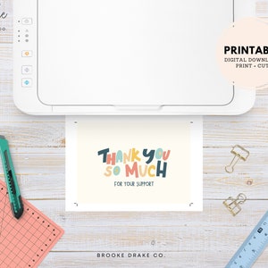 May include: Printable thank you card with colorful text that reads "Thank You So Much" and "For Your Support". The card is being printed on a white printer.