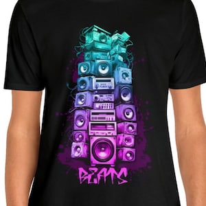 May include: A black t-shirt with a graphic of a stack of vintage stereos in a rainbow color gradient. The graphic is surrounded by a purple and blue paint splatter effect. The text "BEATS" is printed in pink and purple below the graphic.