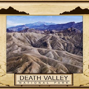 May include: A framed photograph of Death Valley National Park, featuring a panoramic view of the rugged, brown, and tan colored mountains. The text "DEATH VALLEY NATIONAL PARK" is printed in white on a black banner at the bottom of the image.
